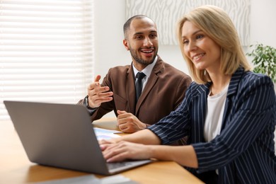 Photo of Coworkers with laptop working together in office