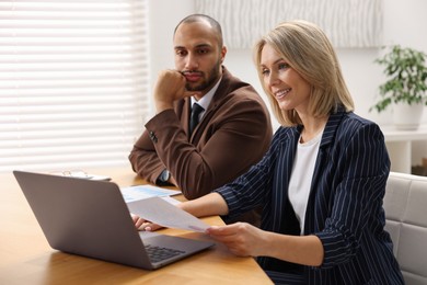 Photo of Coworkers with laptop working together in office