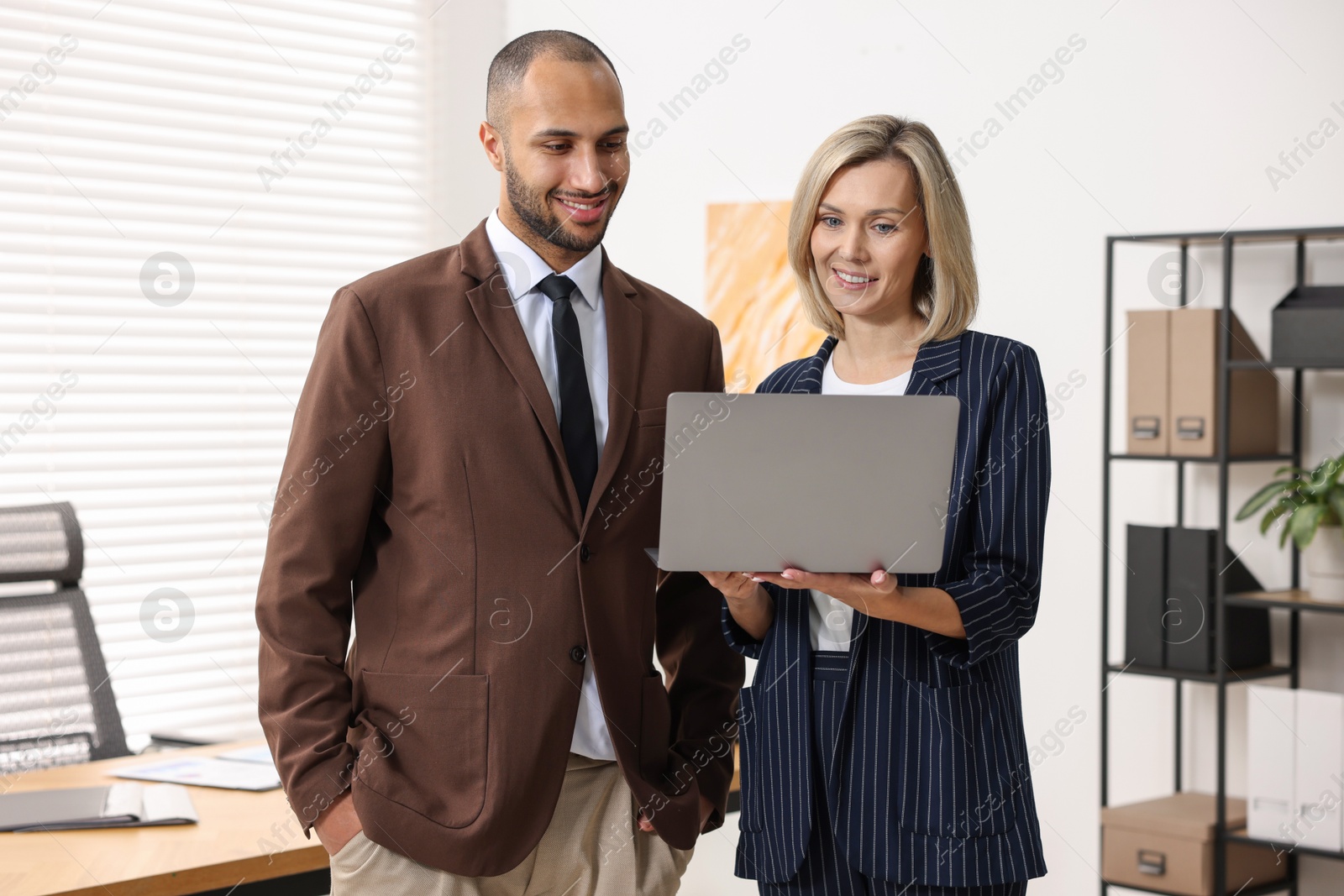 Photo of Coworkers with laptop working together in office