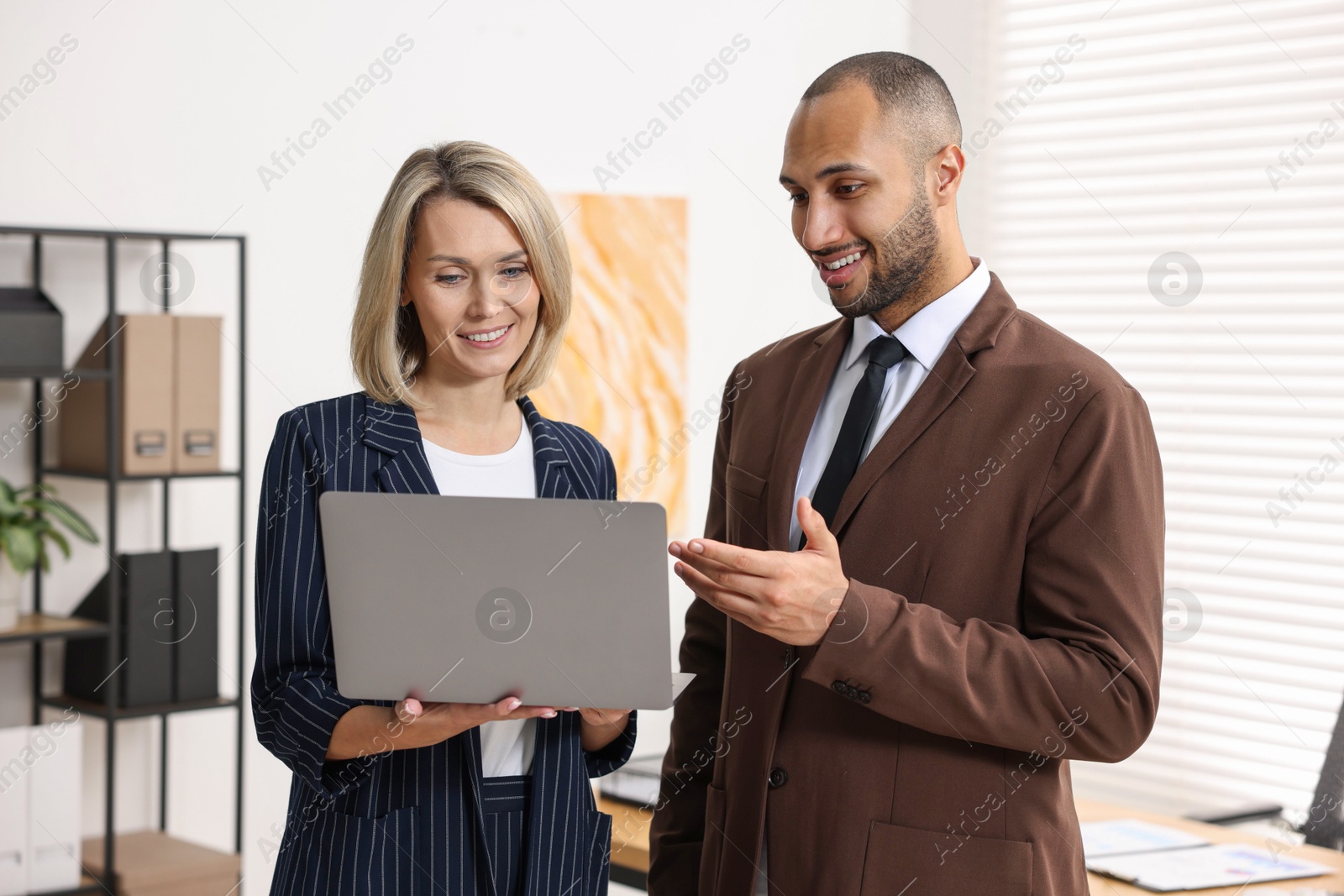 Photo of Coworkers with laptop working together in office