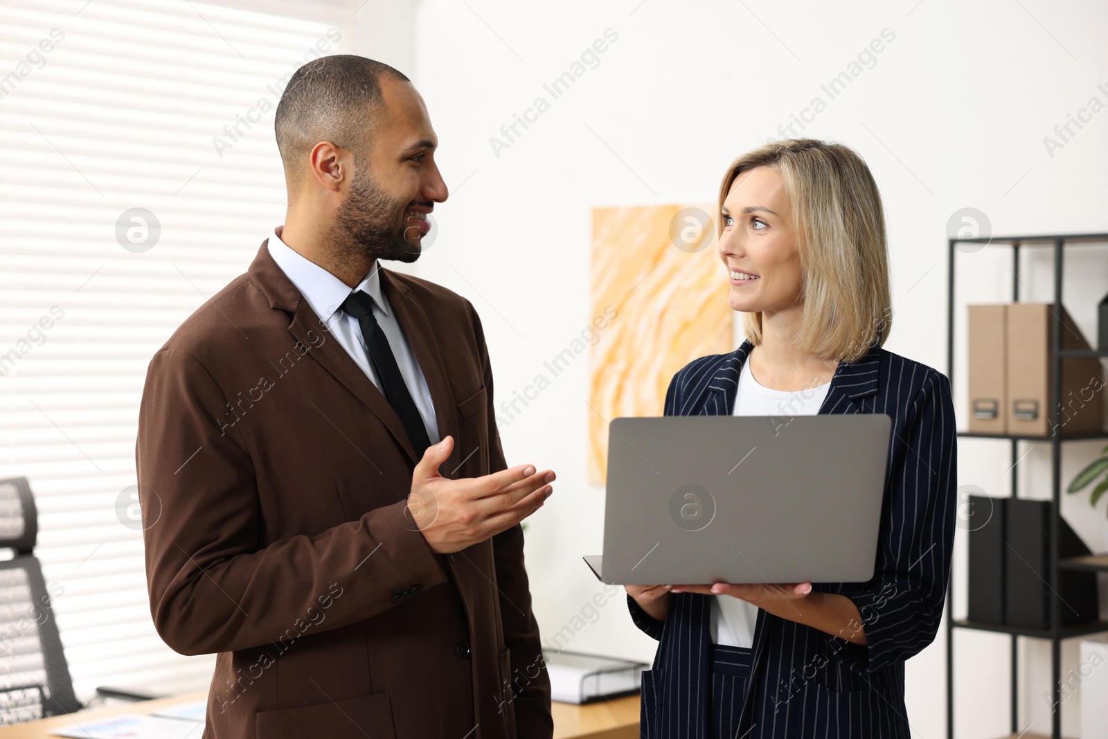 Photo of Coworkers with laptop working together in office