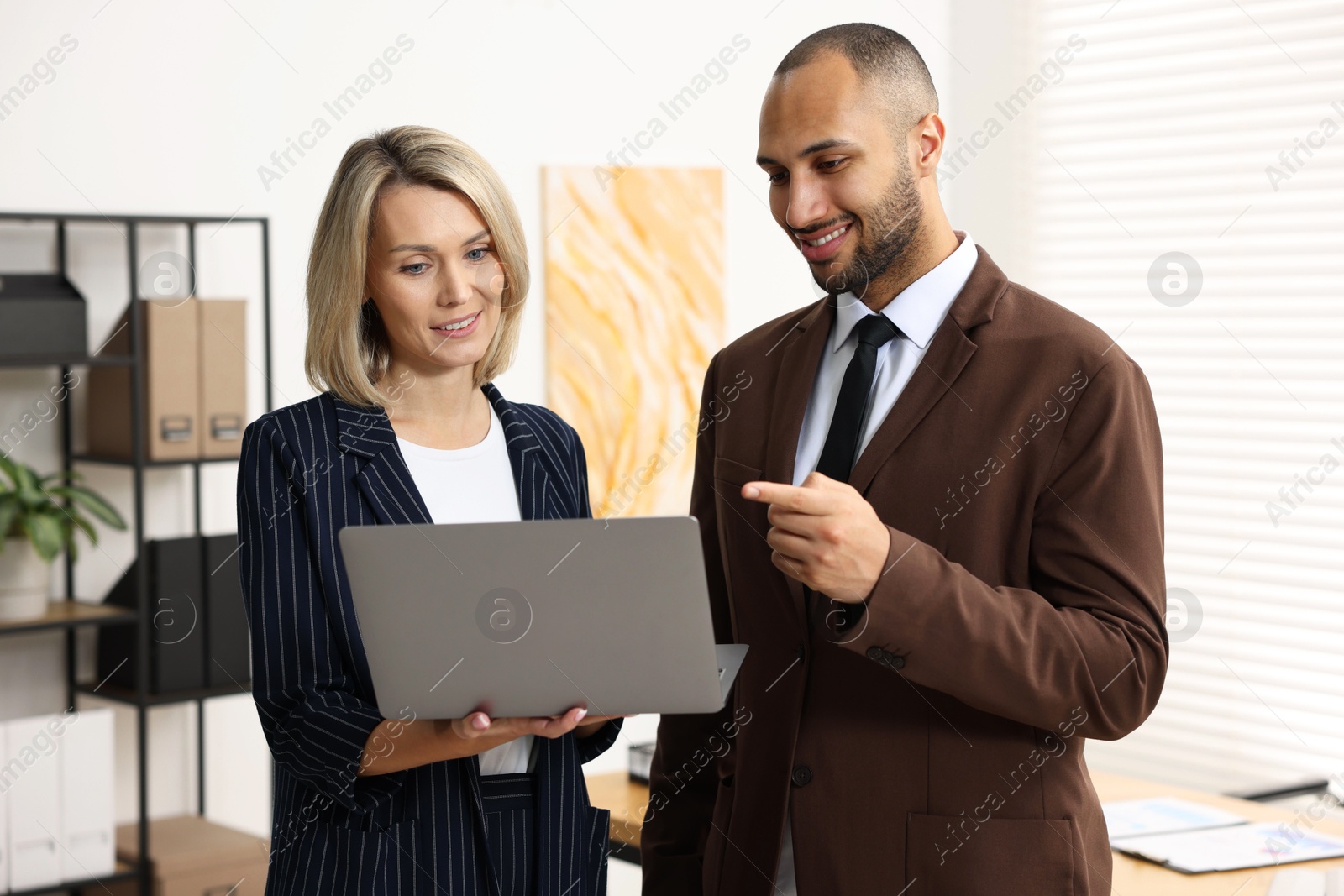 Photo of Coworkers with laptop working together in office