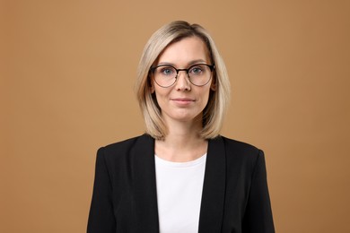 Photo of Portrait of businesswoman in glasses on beige background