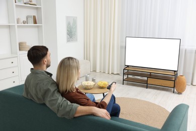 Photo of Lovely couple watching tv on couch at home