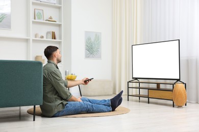 Photo of Man watching tv on floor at home