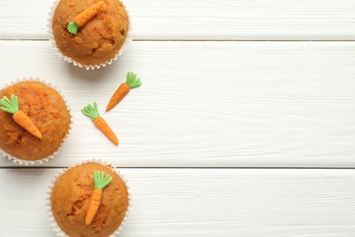 Photo of Tasty carrot muffins on white wooden table, flat lay. Space for text