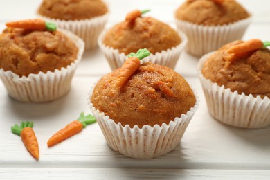 Photo of Tasty carrot muffins on white wooden table, closeup