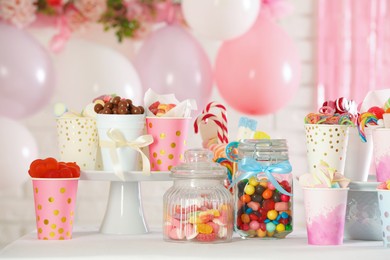 Photo of Candy bar. Many different sweets on table in festive decorated room