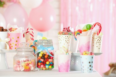 Photo of Candy bar. Many different sweets on table in festive decorated room