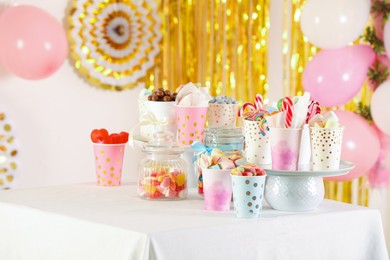 Photo of Candy bar. Many different sweets on table in festive decorated room