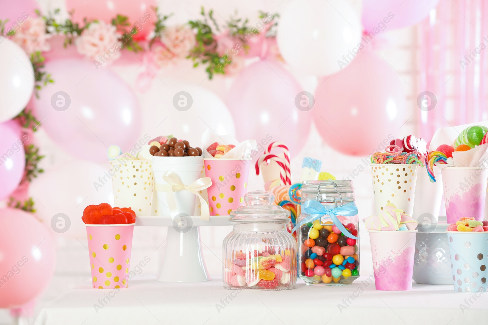 Photo of Candy bar. Many different sweets on table in festive decorated room