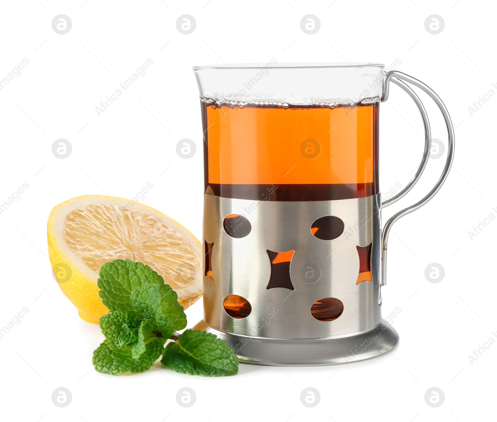 Photo of Glass of aromatic tea in holder, lemon and mint isolated on white