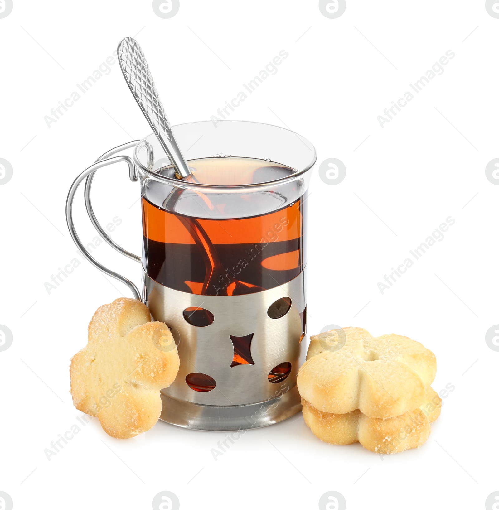 Photo of Glass of aromatic tea in holder, spoon and cookies isolated on white