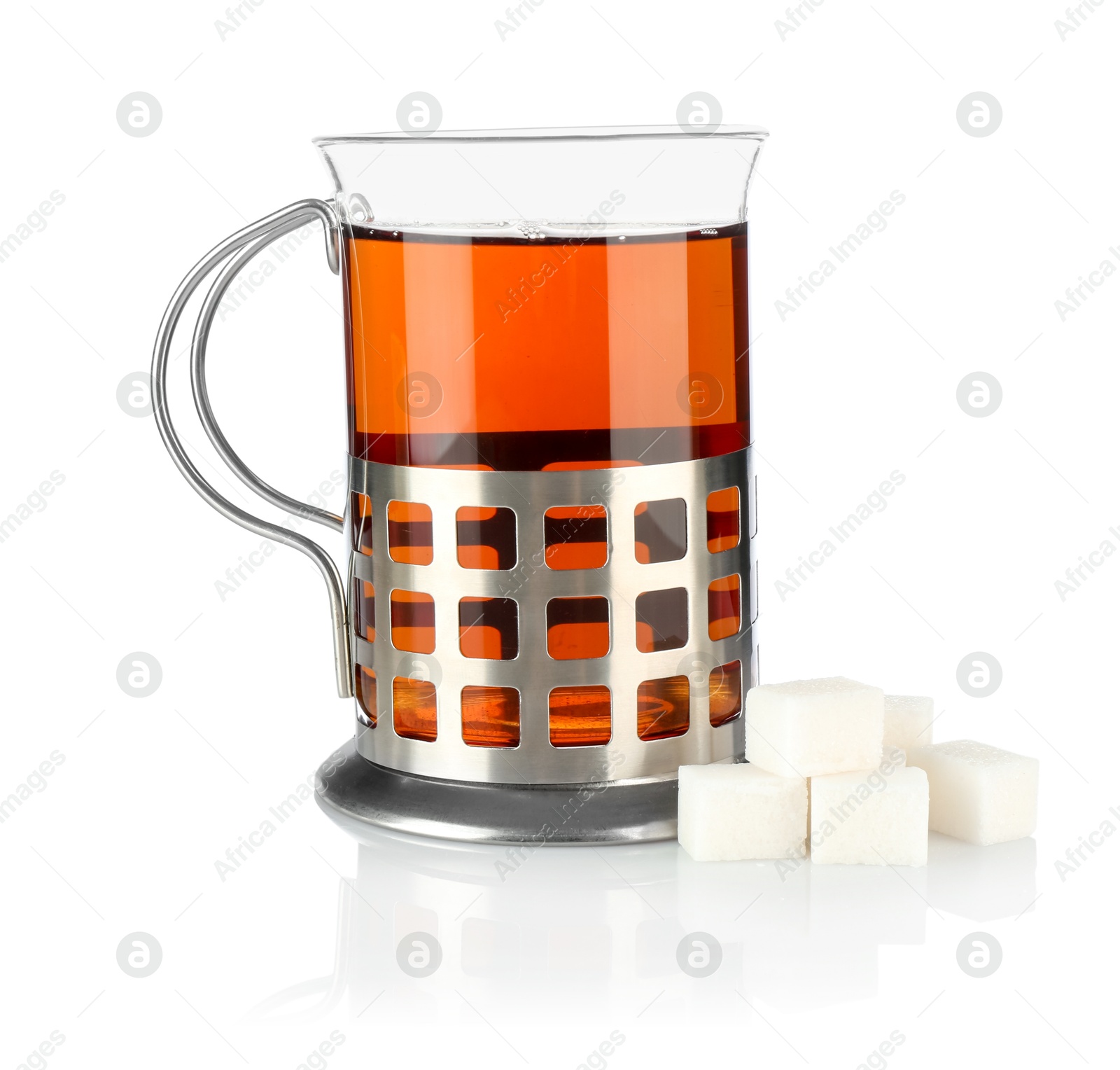 Photo of Glass of aromatic tea in holder and sugar cubes isolated on white