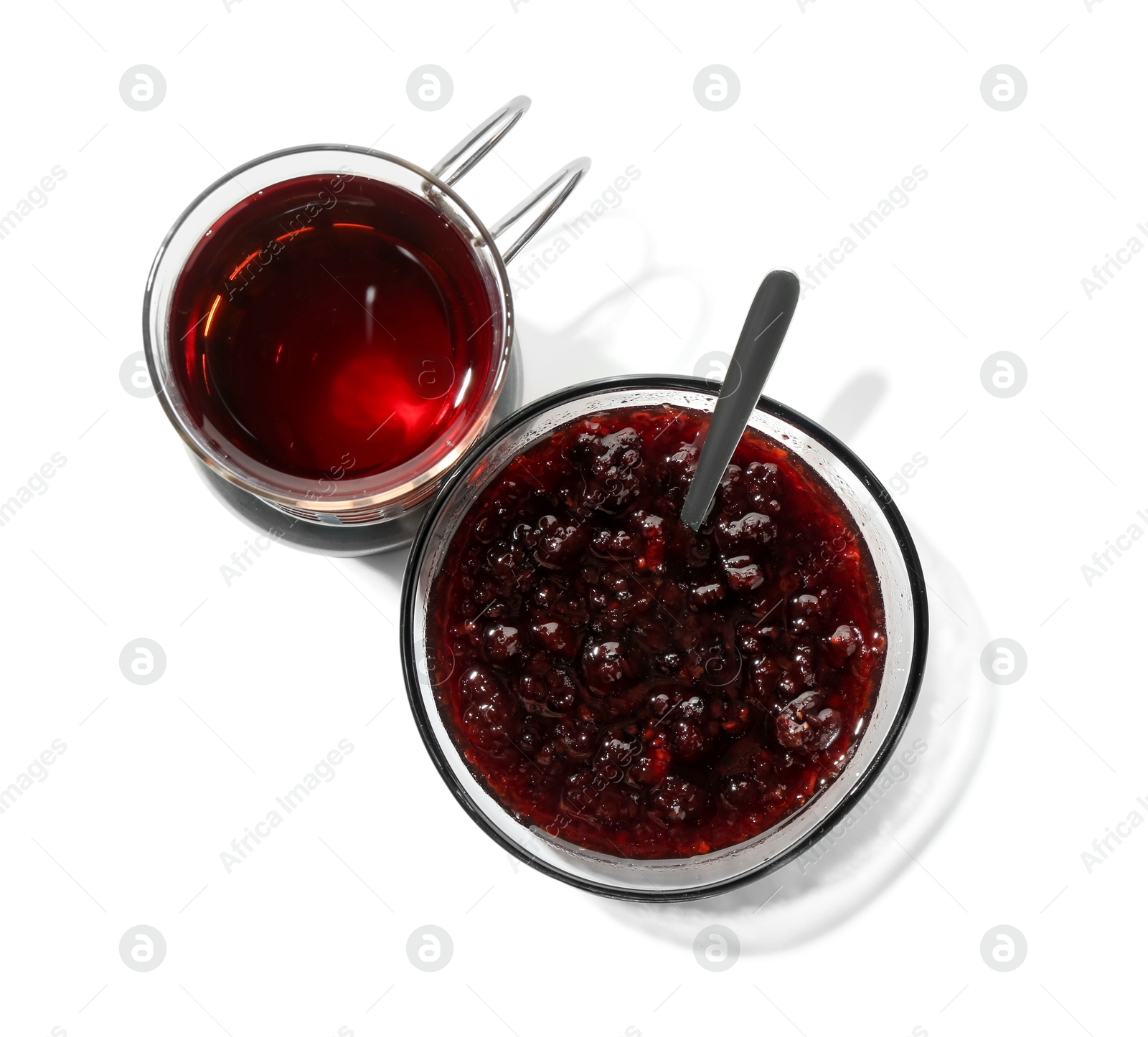 Photo of Glass of aromatic tea in holder and jam isolated on white, top view