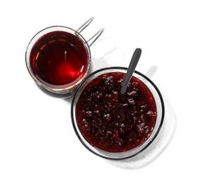 Photo of Glass of aromatic tea in holder and jam isolated on white, top view