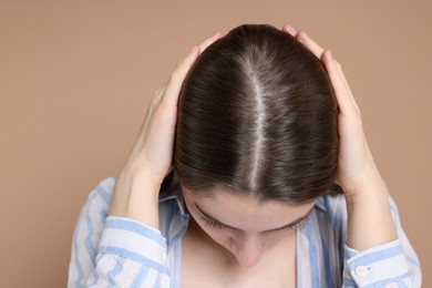 Photo of Girl with hair loss problem on dark beige background