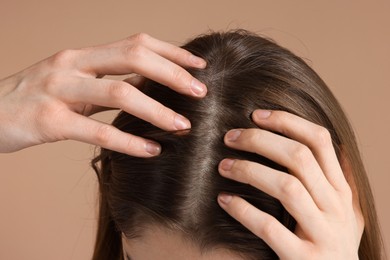 Girl with hair loss problem on dark beige background, closeup