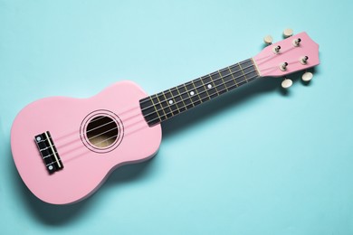 Photo of One ukulele on light blue background, top view