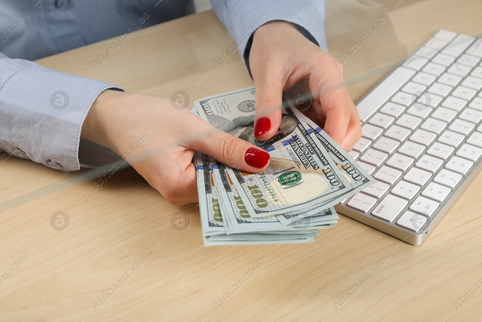 Photo of Woman with dollar banknotes at table in money exchange, closeup