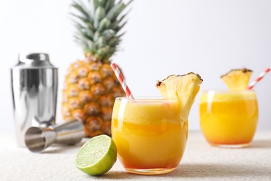 Photo of Tasty pineapple cocktail in glasses served on white table