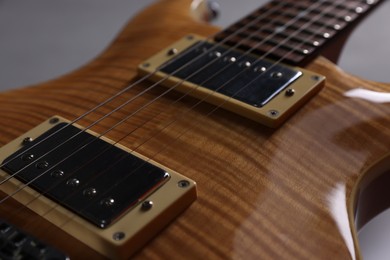 Photo of Modern electric guitar on grey background, closeup