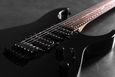 Photo of Modern electric guitar on black background, closeup