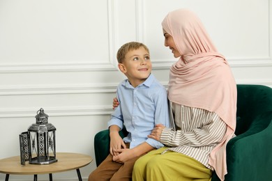 Photo of Muslim woman and her son spending time together at home