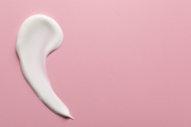 Photo of Cream on pink background, top view and space for text. Sample of cosmetic product