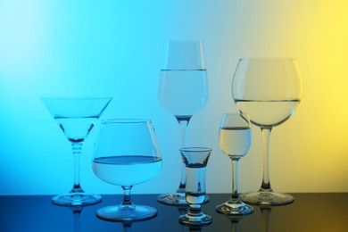 Photo of Different glasses with water on table, color tone effect