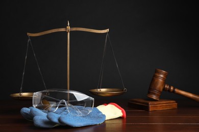 Photo of Accident at work concept. Gavel, scales and construction worker's protective gear on wooden table, selective focus