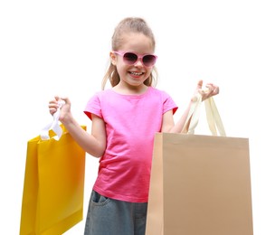 Happy little girl with shopping bags on white background