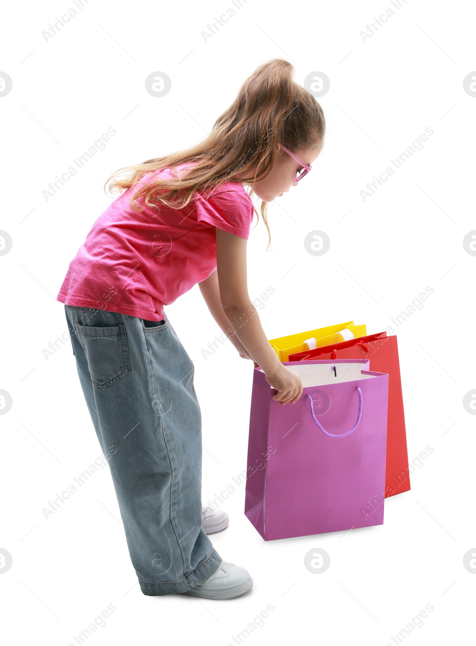 Photo of Cute little girl with shopping bags on white background