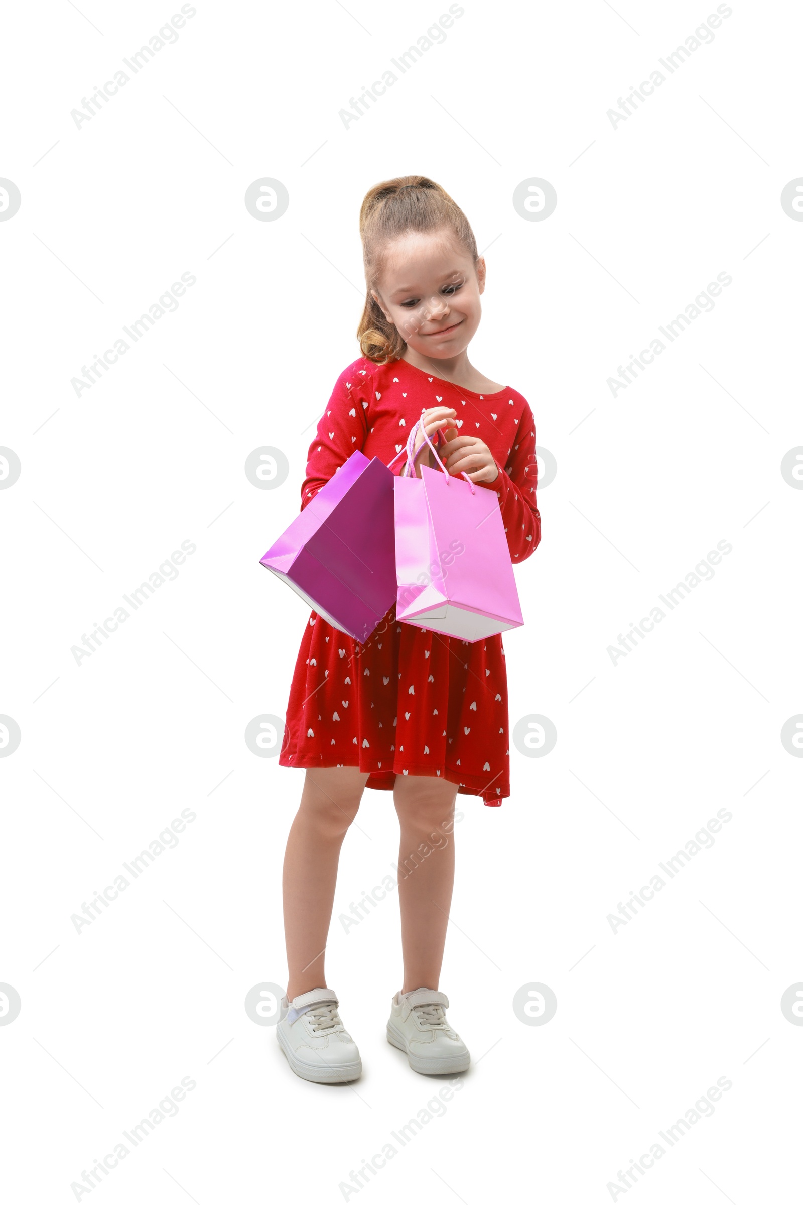 Photo of Cute little girl with shopping bags on white background