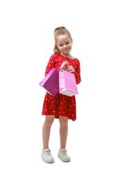 Photo of Cute little girl with shopping bags on white background