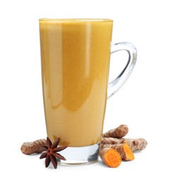 Photo of Delicious turmeric latte in glass cup, roots and anise star isolated on white