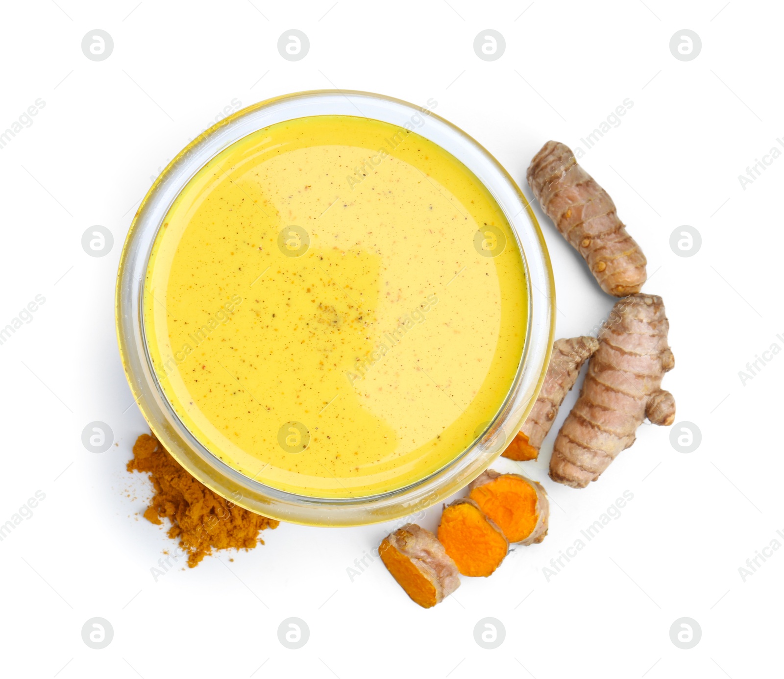 Photo of Delicious turmeric latte in glass, powder and roots isolated on white, top view