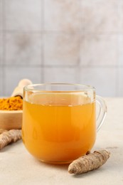 Photo of Aromatic turmeric tea, rhizomes and powder on white textured table, closeup. Space for text