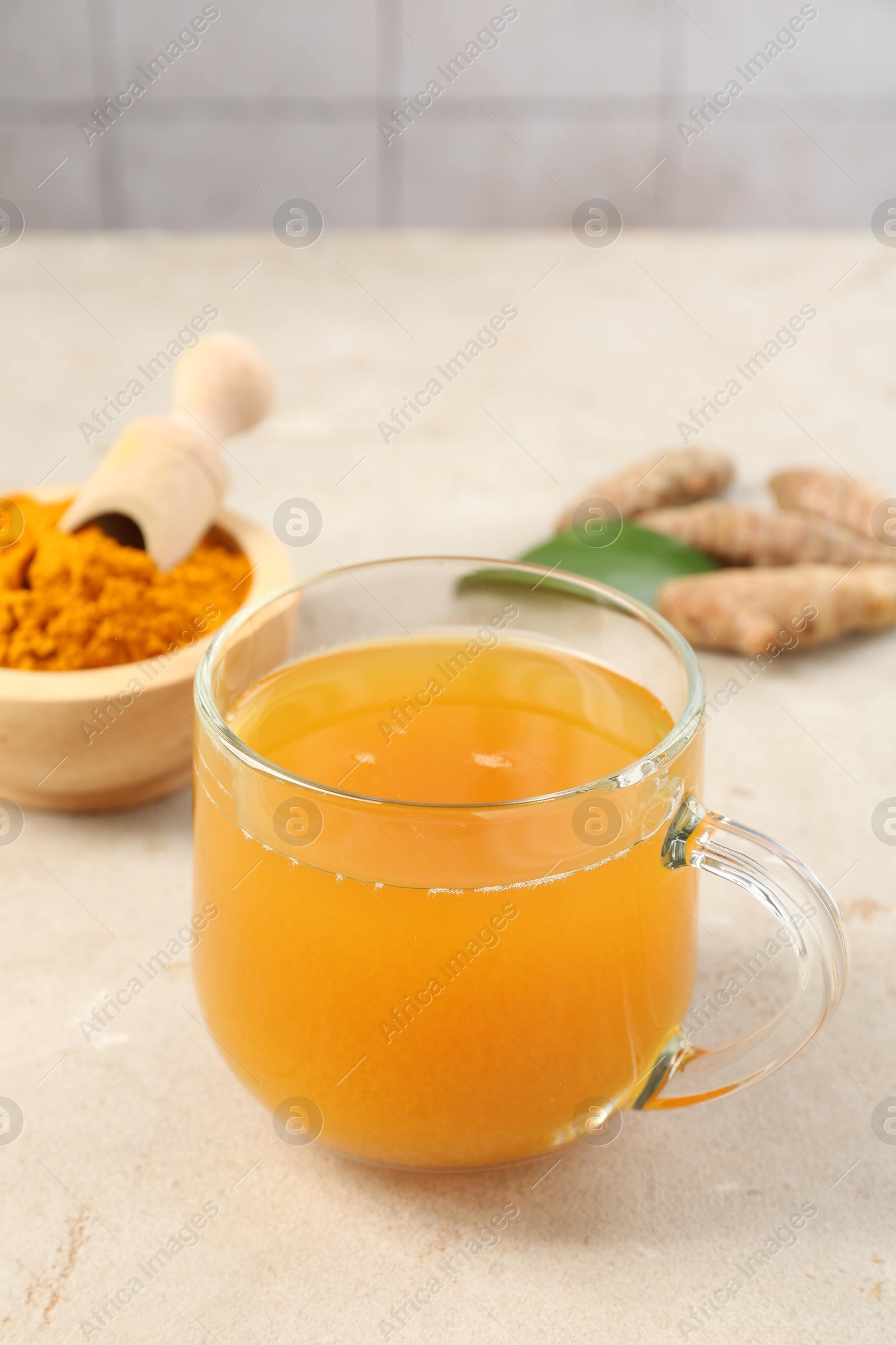 Photo of Aromatic turmeric tea, rhizomes and powder on white textured table, closeup. Space for text