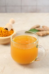 Photo of Aromatic turmeric tea, rhizomes and powder on white textured table, closeup. Space for text