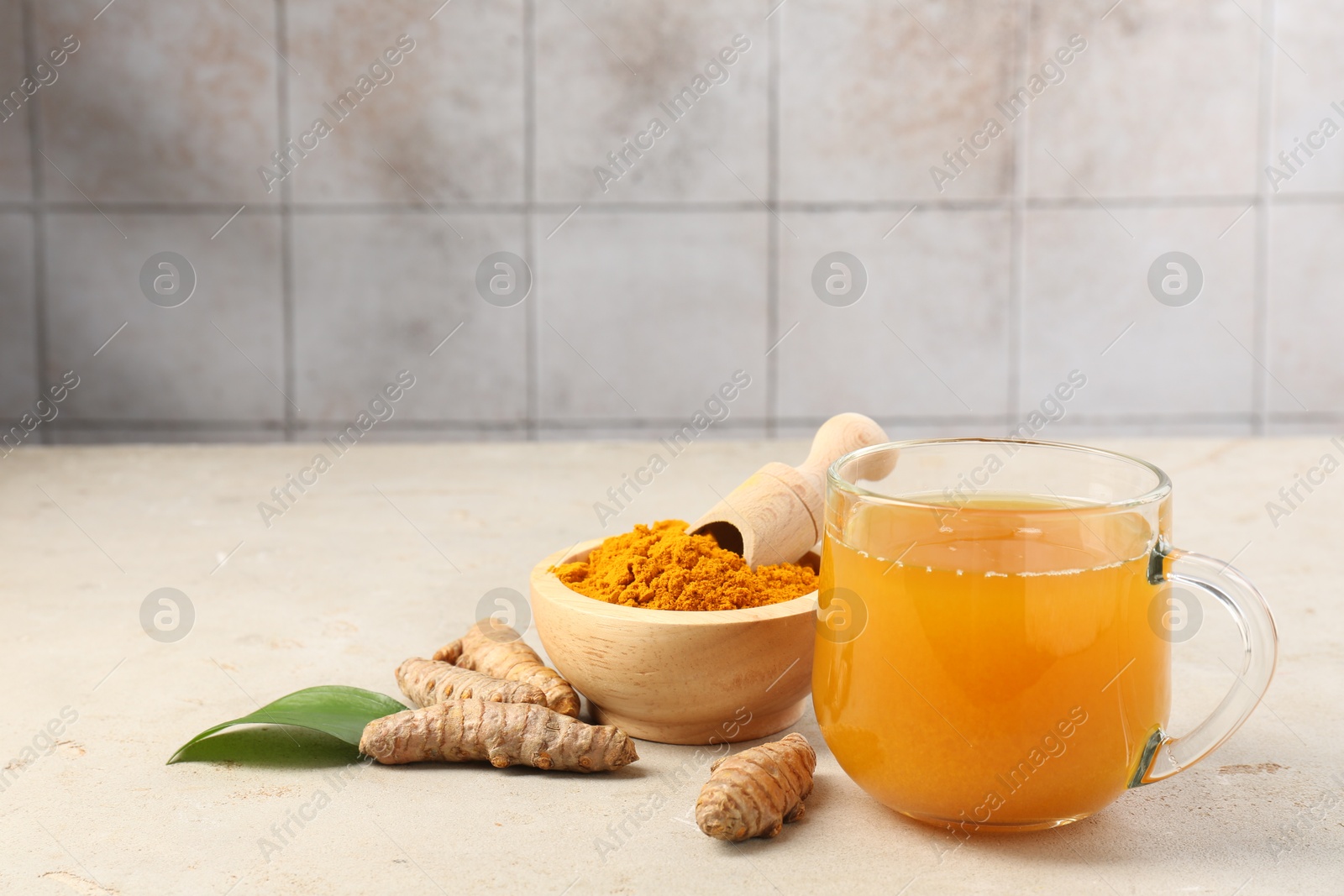 Photo of Aromatic turmeric tea, rhizomes and powder on white textured table