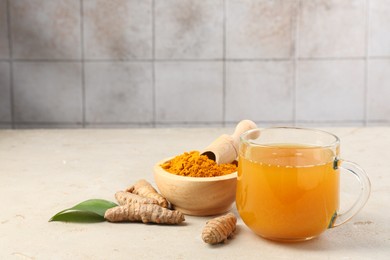 Photo of Aromatic turmeric tea, rhizomes and powder on white textured table