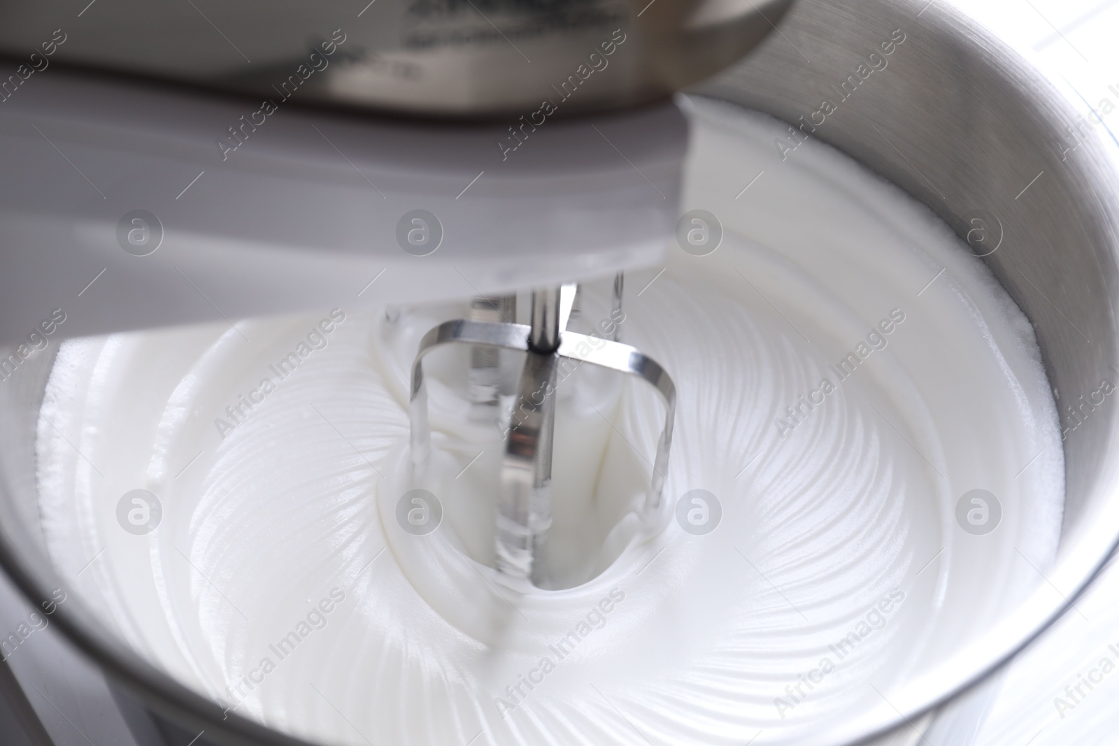 Photo of Mixing whipped cream in bowl of stand mixer, closeup