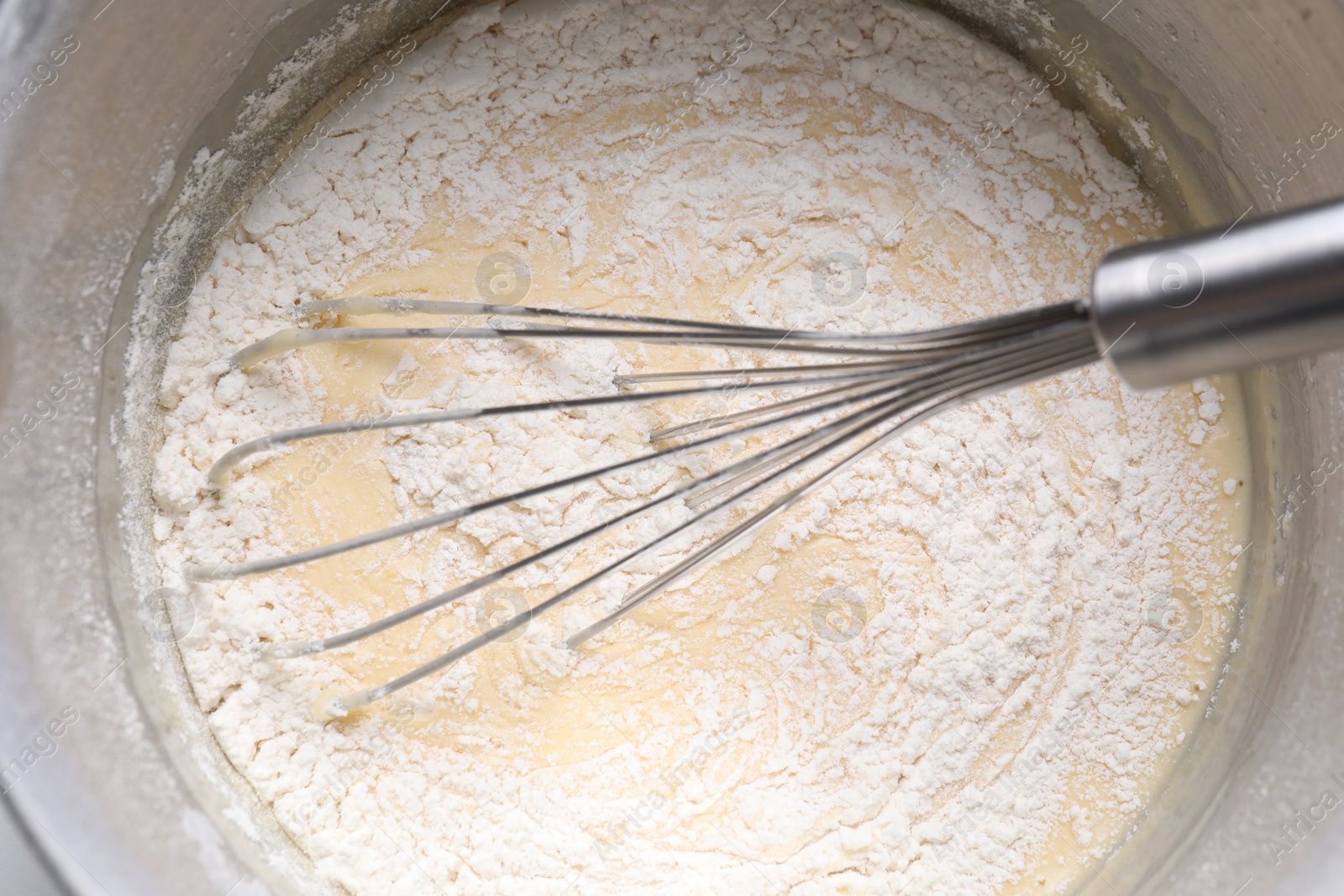 Photo of Whisk and bowl of dough, top view