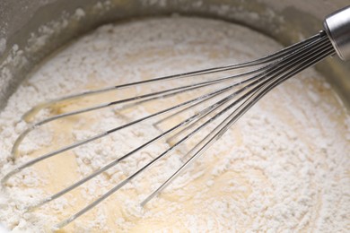 Photo of Whisk and bowl of dough, closeup view