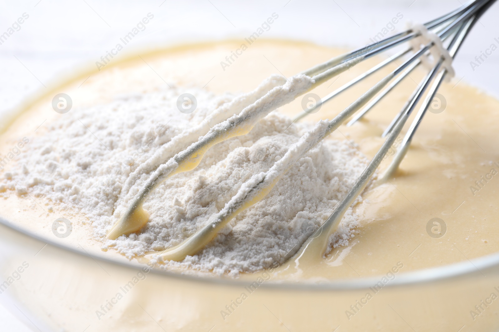 Photo of Whisk and bowl of dough, closeup view