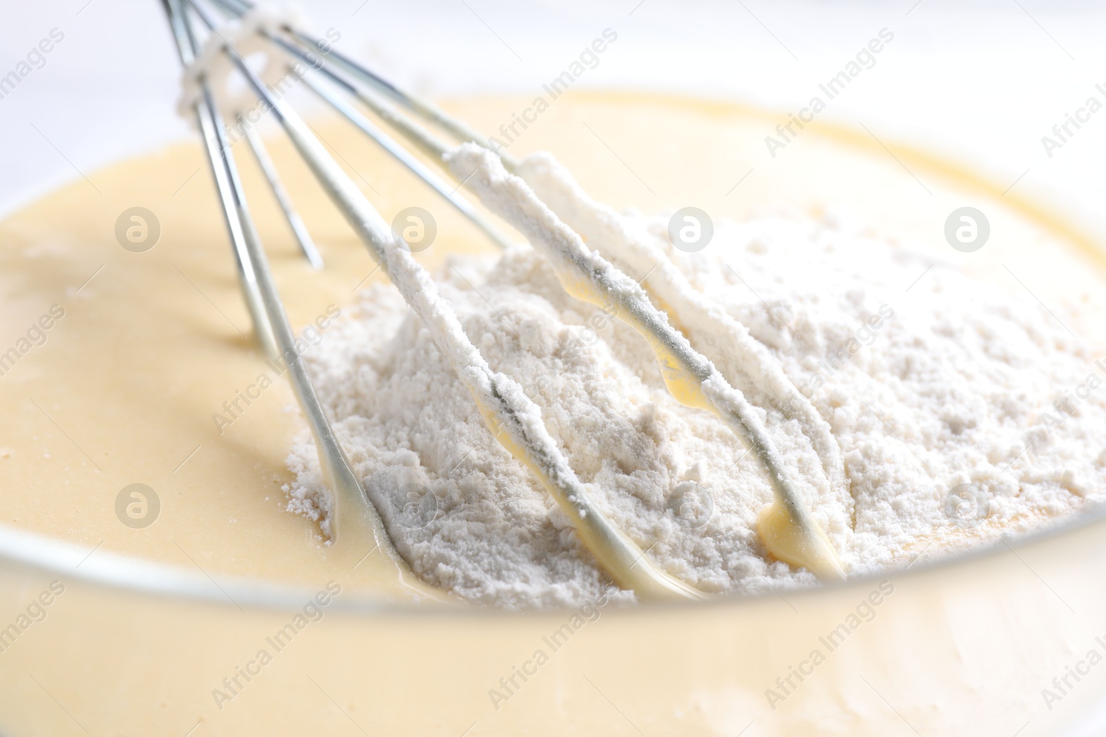 Photo of Whisk and bowl of dough, closeup view