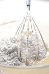 Photo of Whisk and bowl of dough, closeup view