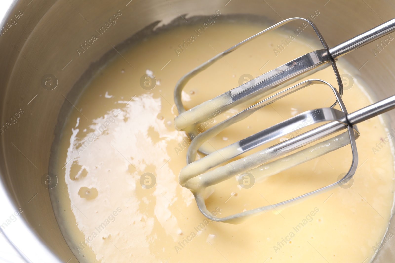 Photo of Making dough in bowl with hand mixer, above view