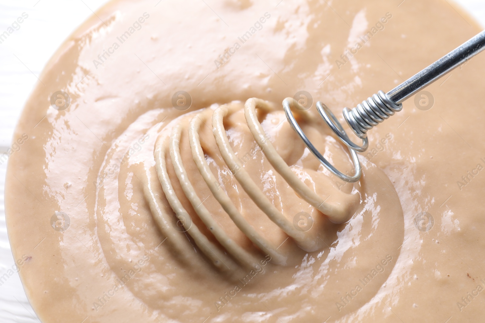 Photo of Whisk and bowl of dough, closeup view